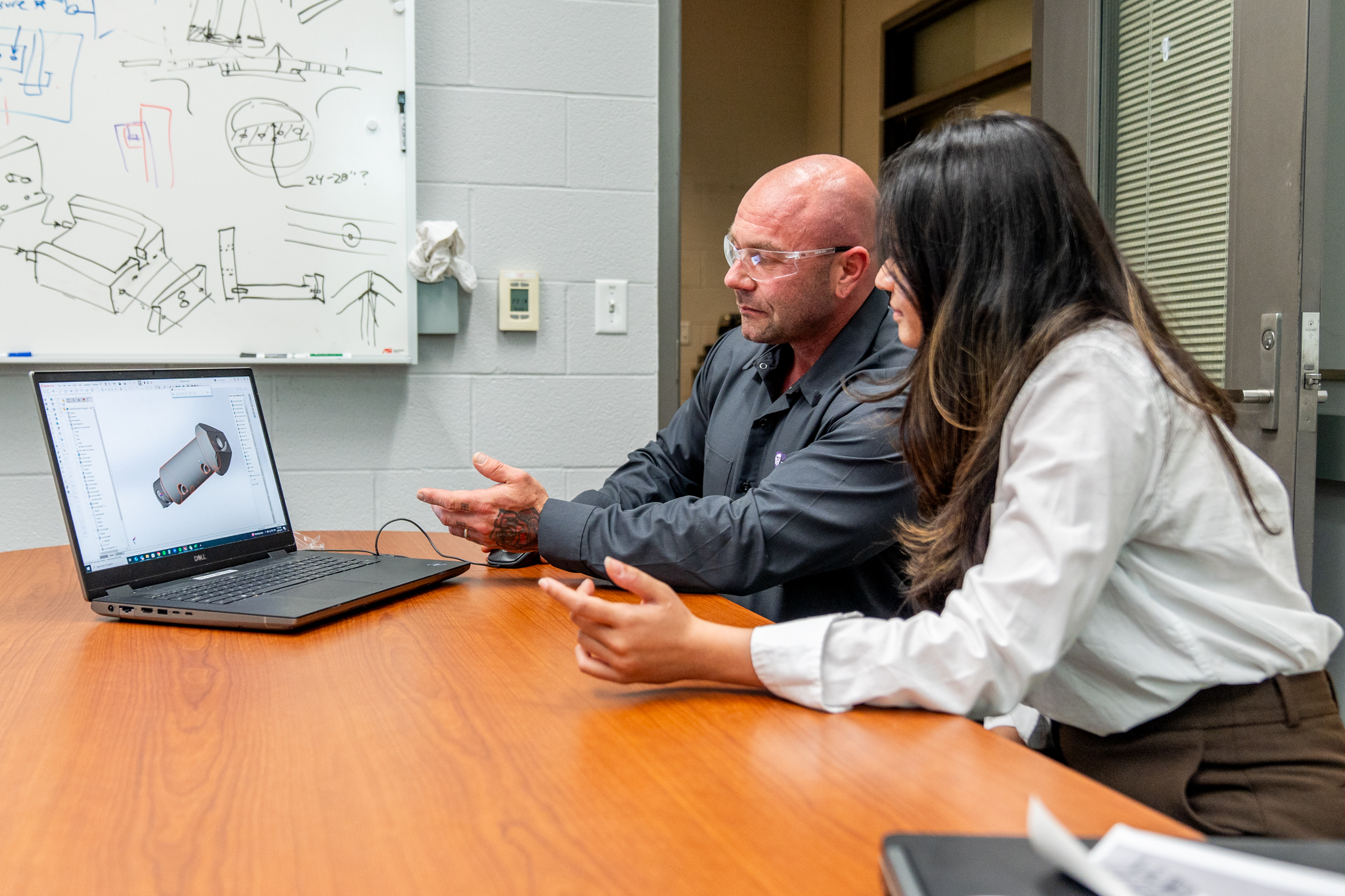 UMS technician showing the client a CAD image on the laptop