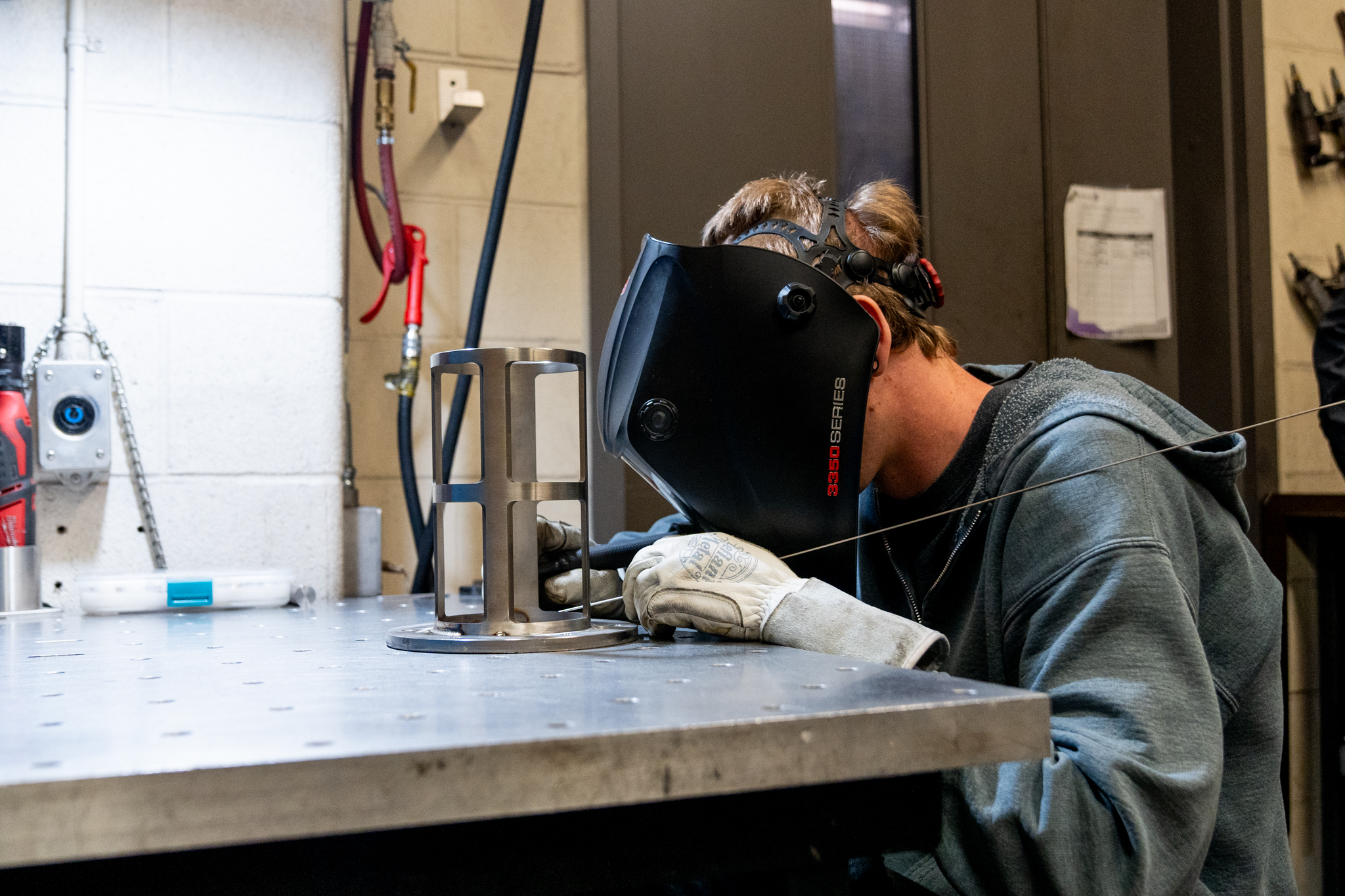 technician wearing a safety mask working on a piece of reactor